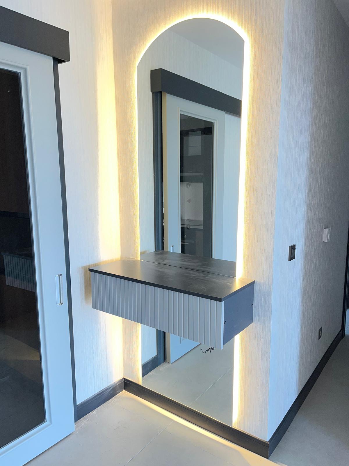 Kavisli LED aydınlatmalı ayna ve çıtalı çekmeceli duvara monte modern antre konsolu